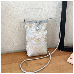 Detail of vintage Chinese embroidery on silver-grey fabric mobile phone crossbody bag