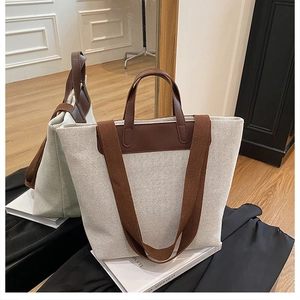 Detalle del bolso tote de lona crema con asas de cuero marrón y vista lateral en el espejo