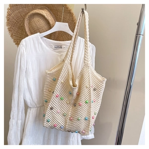 Close-up of cream crochet tote bag featuring colorful bead accents and woven mesh texture