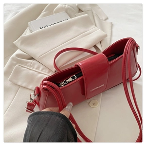 Detailed macro view of vibrant red patent leather shoulder bag with zipper closure
