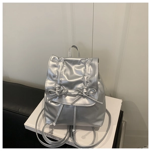 Detailansicht des silbernen Metallic-Rucksacks mit Schleife und glänzender PU-Struktur