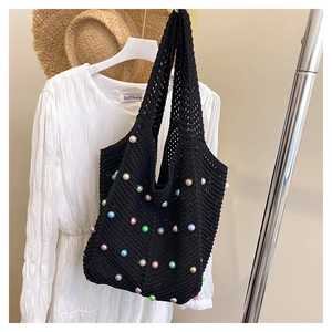 Detail of black woven tote bag with colorful pearl beads and bohemian vacation styling
