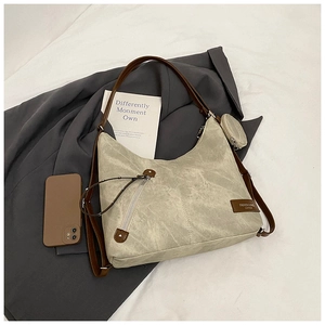 Detail view of cream hobo bag with brown strap and attached mini round coin purse pouch