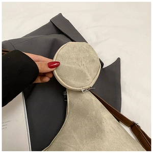 Detail view of khaki canvas tote with round coin purse and brown leather shoulder strap