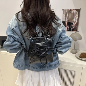 Glossy black pleated ballet style mini backpack with delicate bows and chain straps