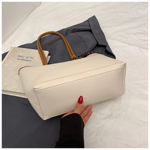 Detail of cream tote bag with lychee leather grain, fine stitching and silk scarf