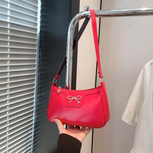 Détail du sac sous le bras rose vif avec boucle nœud argenté et pendentif fleur