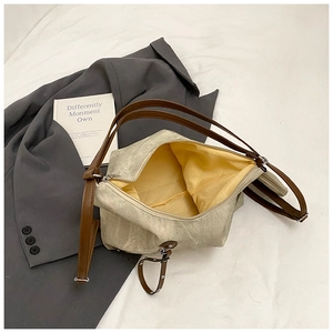 Detailed interior of a cream tote bag with yellow lining and brown shoulder straps