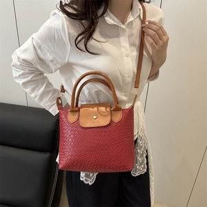 Chic woven tote bag in red faux leather with brown handles and contrast crossbody strap