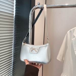 Détail d'un mini sac à bandoulière argenté brillant avec boucle élégante en forme de nœud