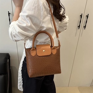Brown woven texture tote bag with top handle and shoulder strap for urban commuting