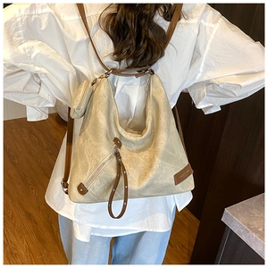 Detail of beige hobo bag with brown straps and mini coin purse in a lifestyle setting