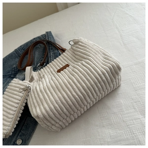 Detail of cream corduroy shoulder bag with brown leather strap and matching coin purse
