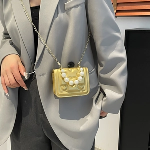 Mini gold crossbody bag with heart embossed pattern and elegant pearl handle
