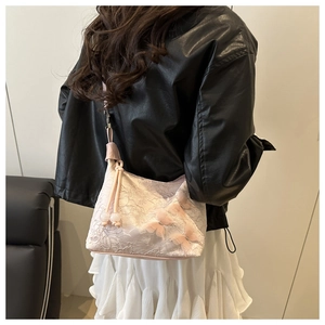 Dettaglio borsa in pizzo rosa con farfalla 3D e decorazioni di perline coulisse