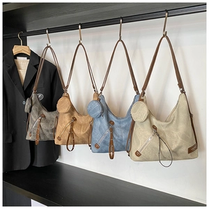 Detail showing vintage pleated tote bags in four colors hanging in a minimalist wardrobe
