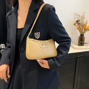Sac bandoulière beige chic avec nœud argenté et finition cuir minimaliste