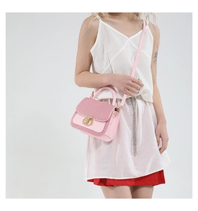 Détail du sac à main en cuir rose avec rabat tissé et fermoir pivotant doré