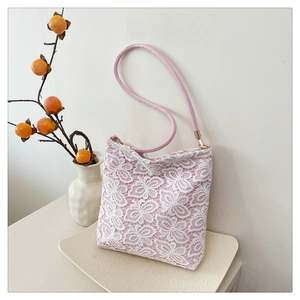 Detailed close-up of a pink lace tote bag with butterfly patterns and leather straps