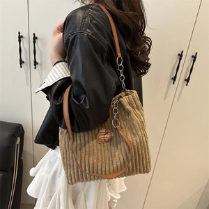 Khaki corduroy shoulder bag with chain strap shown on model for casual daily look