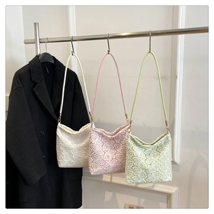Detail of floral lace texture on stylish bucket bags in white, pink, and green colors