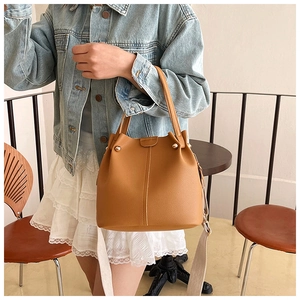 Caramel bucket bag with litchi texture leather and wide woven shoulder strap detail