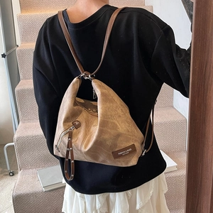Brown faux leather backpack with minimalist triangle design and metal zipper details