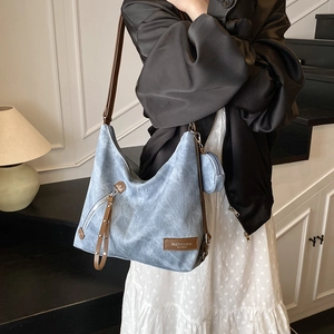 Blue denim tote backpack with brown leather straps and a matching round mini coin purse