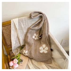 Détail d'un sac tissé avec broderies florales blanches dans un décor rustique chic