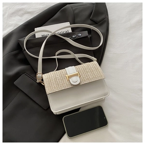 Detail of white leather shoulder bag with straw weave texture and gold metal buckle