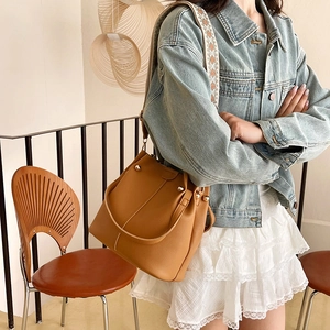 Brown leather bucket bag with jacquard woven strap and gold rivet detailing for women
