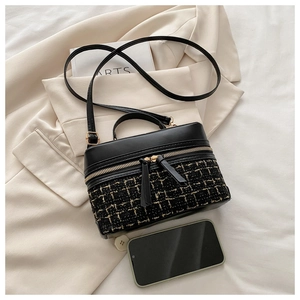 Top view of black tweed and leather box bag with dual zippers and matching smartphone
