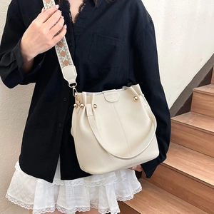 Chic beige lychee grain bucket bag with bohemian embroidered strap for daily commute