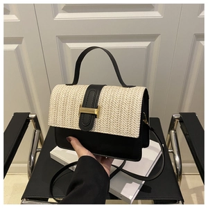 Detail of contrast handbag featuring straw flap, black leather, and gold H-buckle hardware