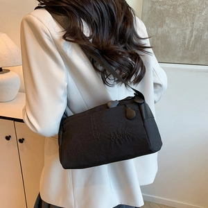 Minimalist black nylon crossbody bag with adjustable wide strap for casual outdoor use