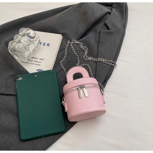 Detailed shot of pink mini barrel bag with silver chains and dual zipper design