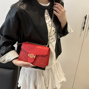Elegant red leather crossbody bag with floral embossing and golden M chain strap