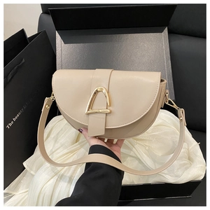 Beige leather saddle bag with gold D-ring buckle showcased in premium gift packaging