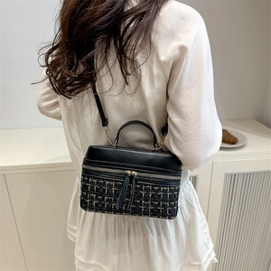 Minimalist tweed and black leather box bag with dual zipper and tassel handle detail