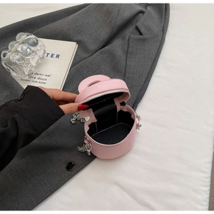 Detailed view of pink leather bucket bag with silver chain and dual zipper opening