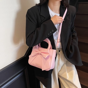 Chic pink PU leather handbag with large decorative bow and adjustable crossbody strap