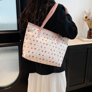 Women's pink tote bag with heart and pig patterns featuring leather shoulder straps