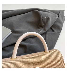 Détail de la texture tressée du sac et poignée en cuir avec anneau doré élégant