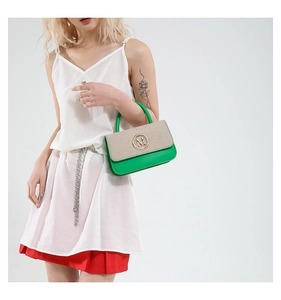 Détail du sac à main tissé vert et beige avec logo M doré et poignée ronde