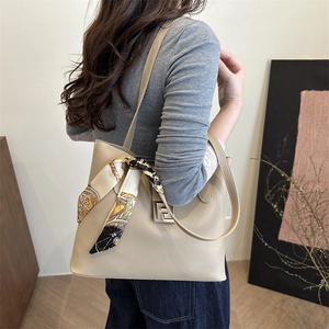 Chic beige leather shoulder bag with decorative silk scarf and gold metal buckle