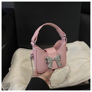 Détail du mini sac à main rose avec nœud métallique argenté et bandoulière chaîne