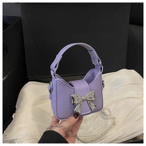 Détail du mini sac à main violet avec nœud argenté et bandoulière chaîne amovible