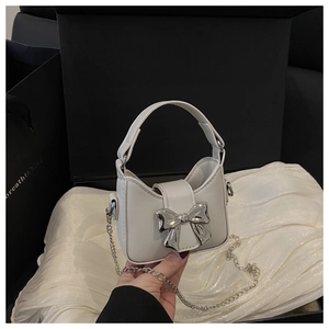 Gros plan du mini sac à main blanc avec boucle nœud argenté dans un coffret cadeau