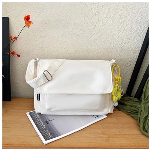 Détail du sac fourre-tout en nylon crème avec bandoulière réglable et pendentif tournesol