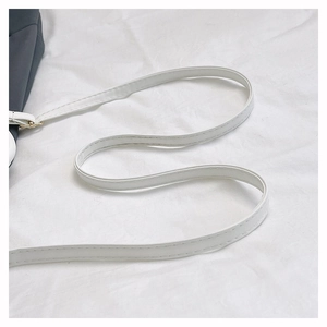 Détail de la bandoulière en cuir PU blanc avec coutures fines et boucle en métal
